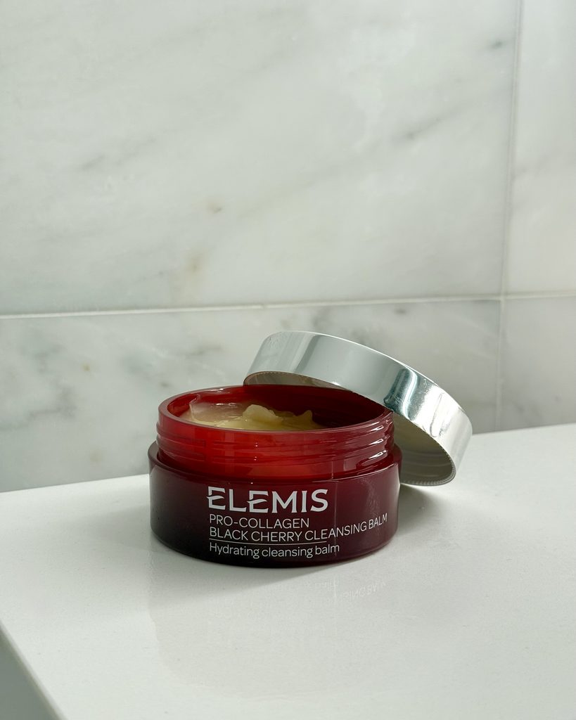 Open jar of ELEMIS Pro-Collagen Black Cherry Cleansing Balm on marble