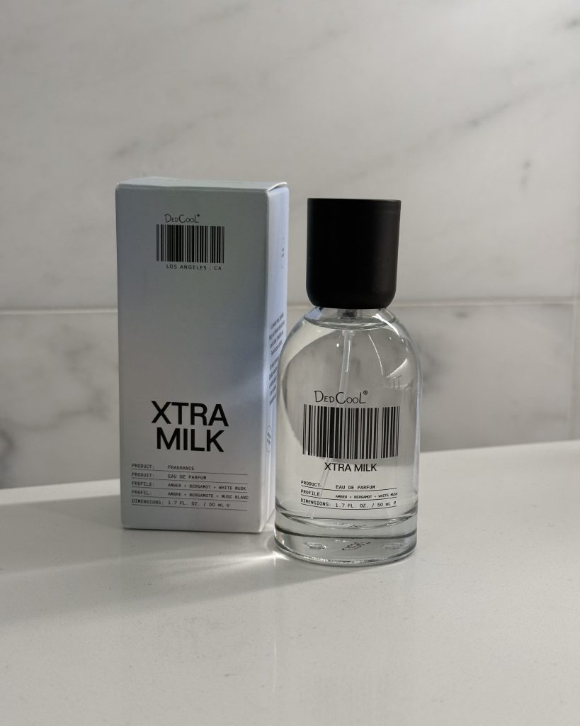 DedCool Xtra Milk perfume bottle beside its packaging on marble