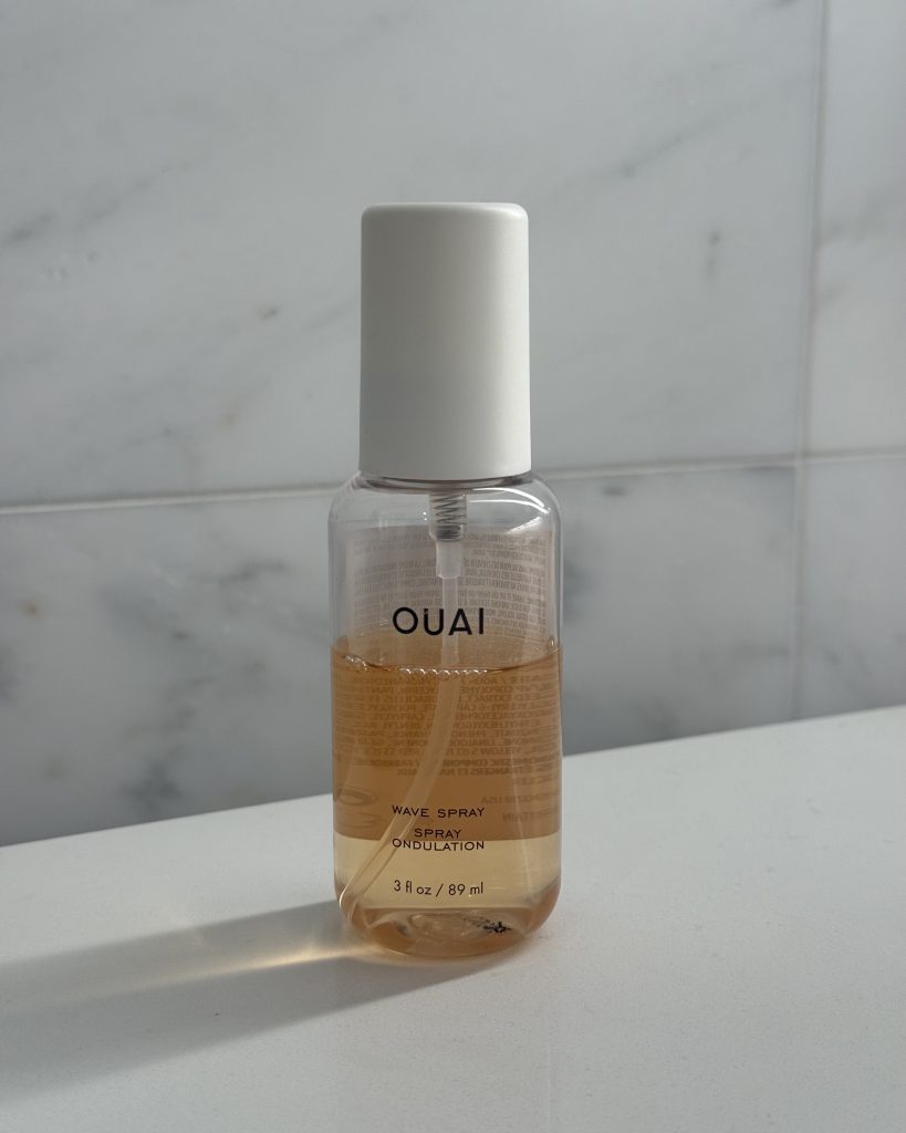 OUAI Wave Spray bottle on a marble background