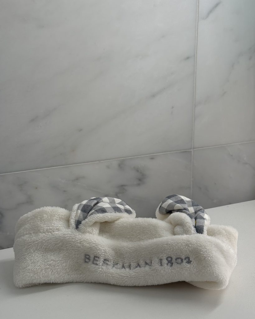 White Beekman 1802 goat ears skincare headband on marble